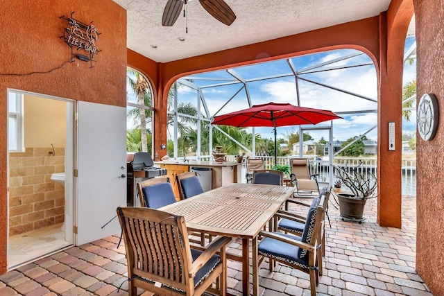 view of patio / terrace featuring ceiling fan and a lanai