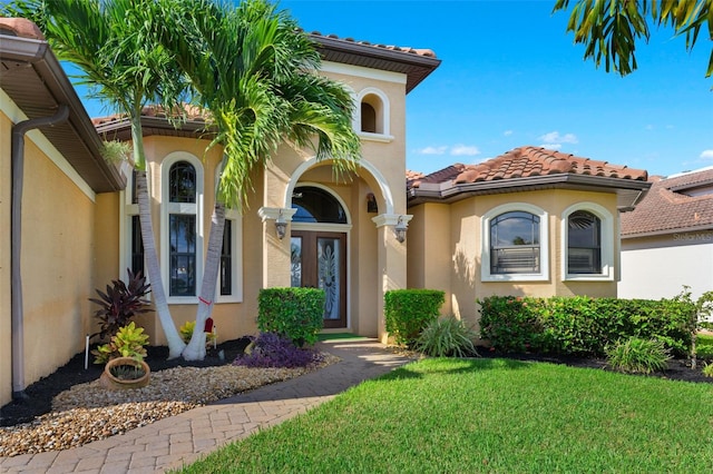 view of exterior entry with a lawn