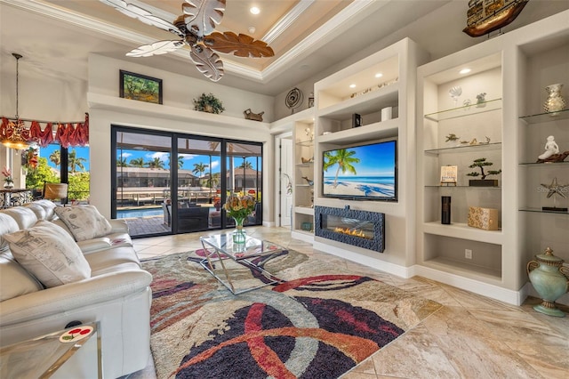 living room with built in shelves, ceiling fan, and ornamental molding