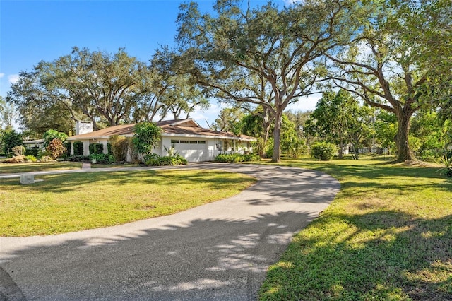 ranch-style home featuring a front lawn and a garage