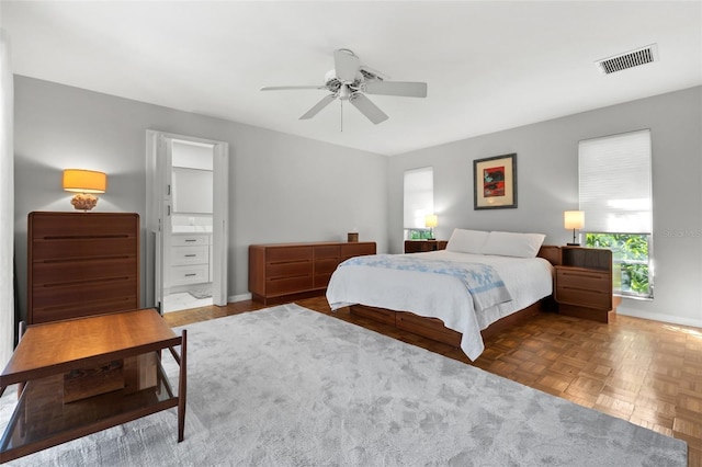 bedroom featuring ensuite bath, ceiling fan, and dark parquet floors