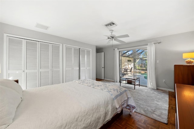 bedroom featuring ceiling fan, dark parquet floors, access to exterior, and two closets