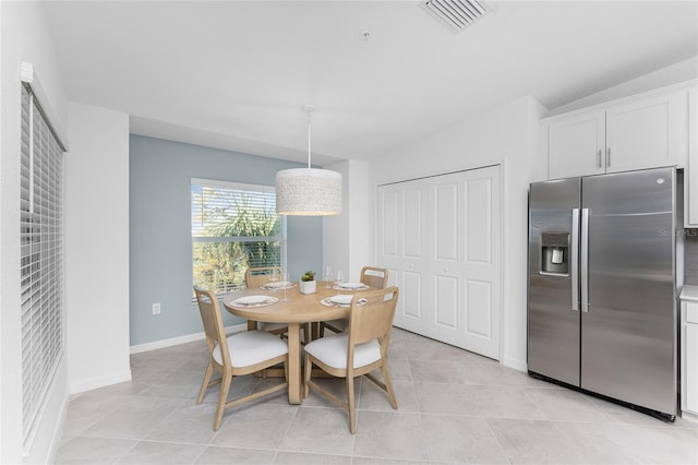 dining room with light tile patterned floors and lofted ceiling