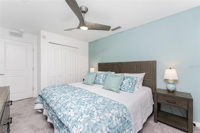 carpeted bedroom with ceiling fan and a closet