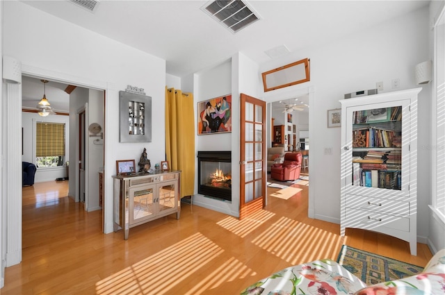 sitting room featuring hardwood / wood-style floors and a multi sided fireplace