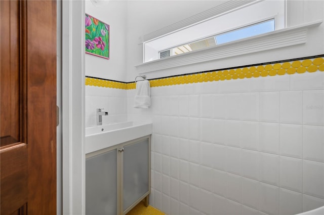 bathroom with vanity and tile walls