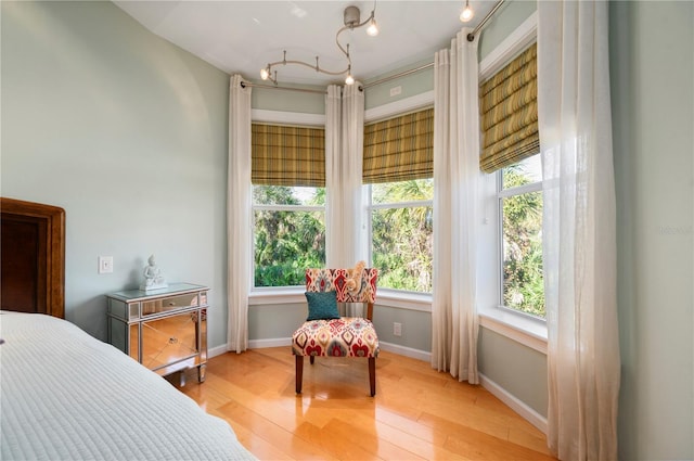 bedroom with light wood-type flooring, ornamental molding, and multiple windows