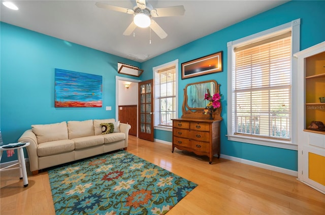 living room with wood-type flooring and ceiling fan