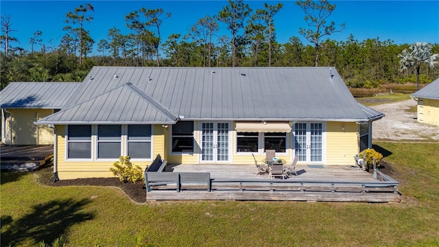 rear view of property featuring french doors, a yard, and a wooden deck