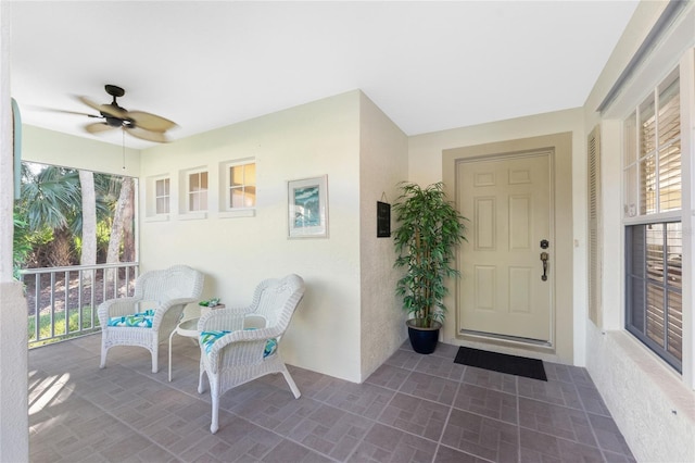 entrance to property featuring covered porch and ceiling fan