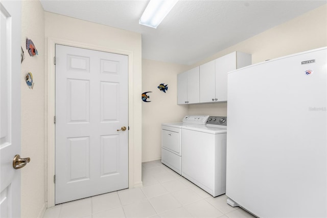 clothes washing area featuring cabinets, a textured ceiling, and washer and clothes dryer