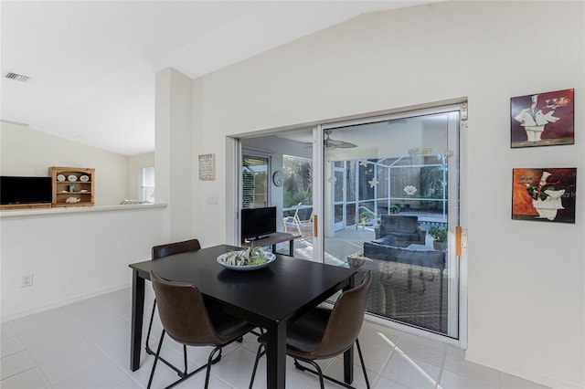 tiled dining area with vaulted ceiling