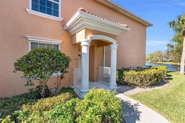 view of exterior entry with a porch and a water view