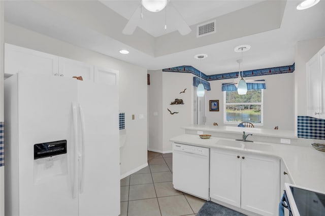 kitchen featuring kitchen peninsula, white appliances, sink, white cabinetry, and hanging light fixtures