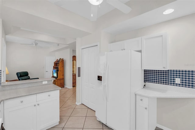 kitchen featuring backsplash, ceiling fan, light tile patterned floors, white cabinets, and white fridge with ice dispenser