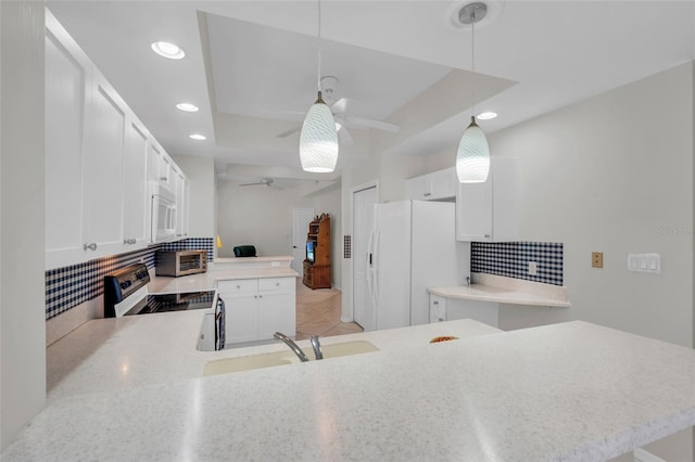 kitchen with kitchen peninsula, white appliances, ceiling fan, pendant lighting, and white cabinets