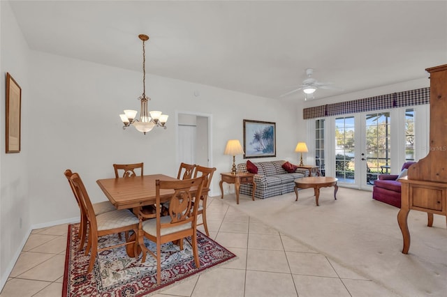 tiled dining room with french doors and ceiling fan with notable chandelier