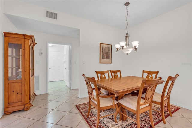 tiled dining room featuring a chandelier