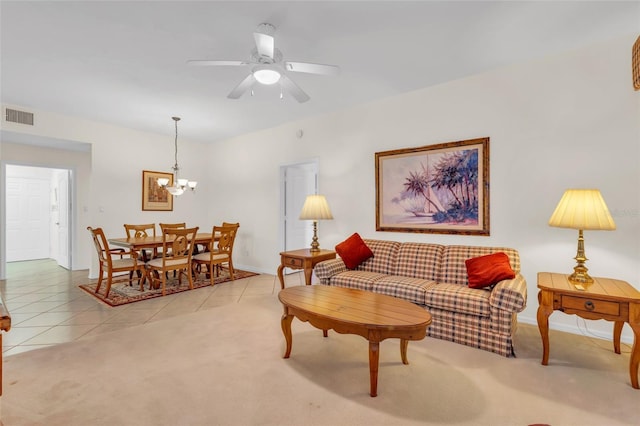 tiled living room featuring ceiling fan with notable chandelier