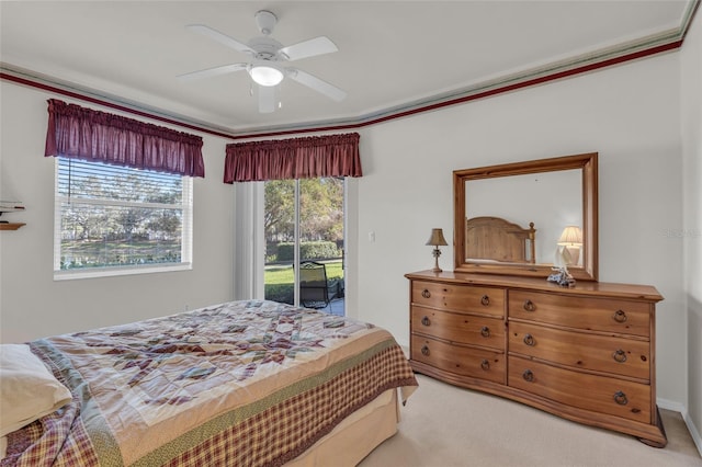 bedroom featuring ceiling fan, access to exterior, light carpet, and multiple windows