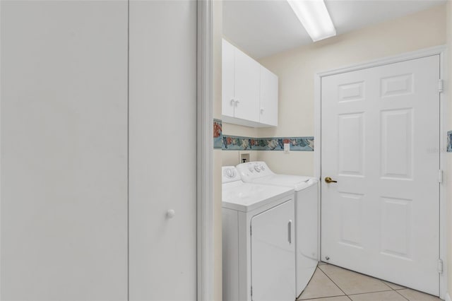 washroom with cabinets, light tile patterned floors, and washer and dryer