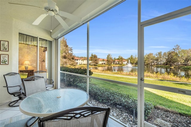 sunroom featuring a water view and ceiling fan