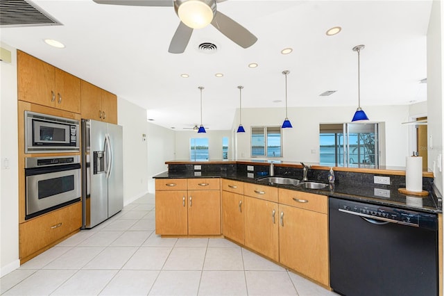 kitchen with ceiling fan, sink, hanging light fixtures, dark stone counters, and appliances with stainless steel finishes