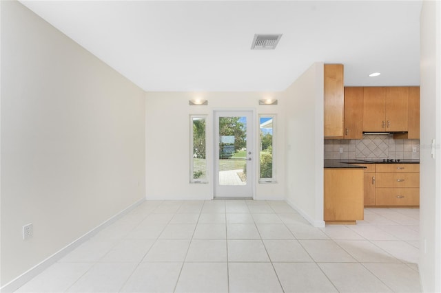 kitchen featuring light tile patterned flooring and backsplash