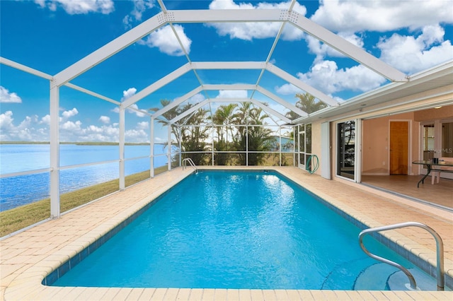 view of swimming pool featuring a water view, a patio area, and a lanai