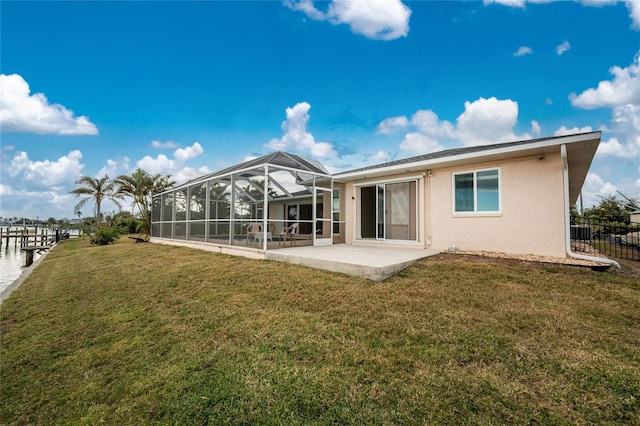 back of property with stucco siding, a patio, fence, a yard, and a lanai