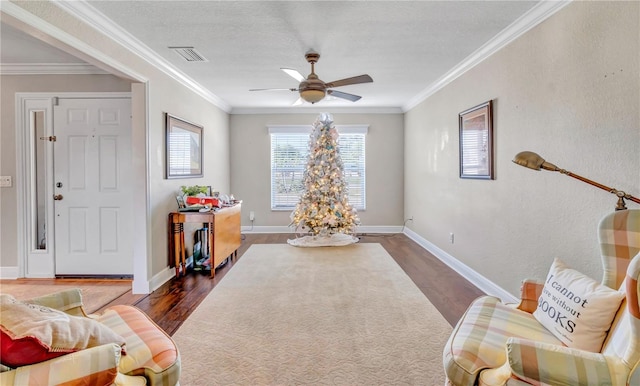 sitting room with crown molding, dark wood-type flooring, and ceiling fan