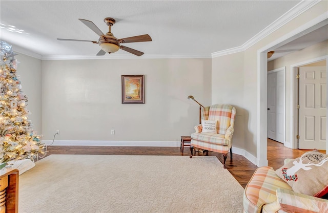 living area featuring hardwood / wood-style flooring, ornamental molding, and ceiling fan