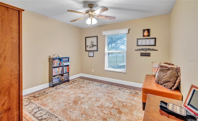 living area featuring wood-type flooring and ceiling fan