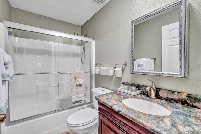 full bathroom with bath / shower combo with glass door, vanity, and toilet