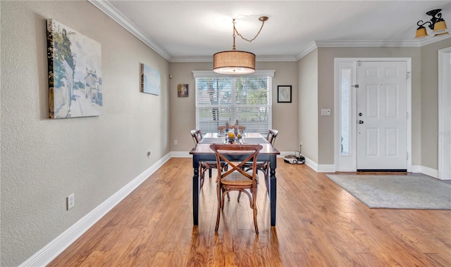 dining space featuring hardwood / wood-style floors and ornamental molding