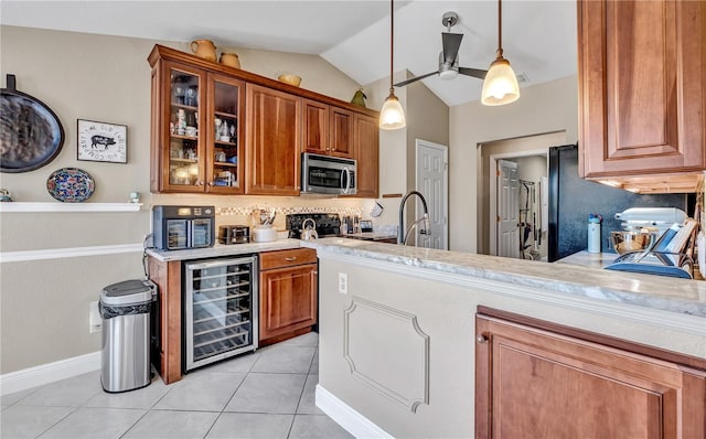 kitchen with wine cooler, lofted ceiling, light tile patterned floors, pendant lighting, and stove