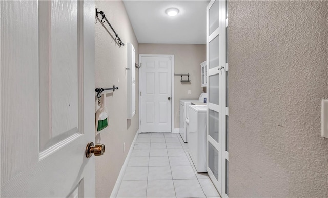 clothes washing area with light tile patterned flooring and independent washer and dryer