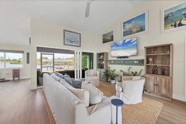 living room featuring ceiling fan, lofted ceiling, and light wood-type flooring