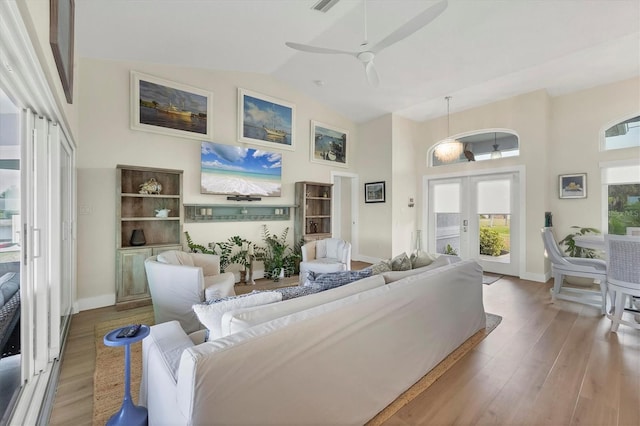 living room with ceiling fan, french doors, wood-type flooring, and lofted ceiling