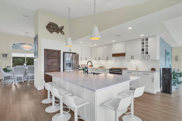 kitchen with white cabinetry, sink, light stone countertops, and appliances with stainless steel finishes