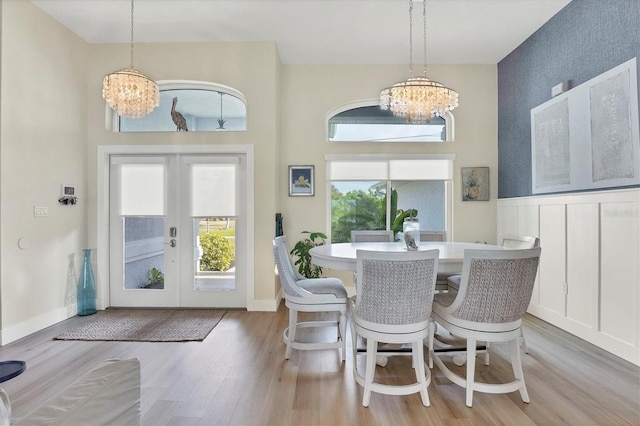 dining room with a notable chandelier, light hardwood / wood-style floors, and french doors