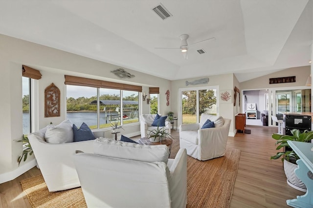 living room featuring a tray ceiling, plenty of natural light, and ceiling fan