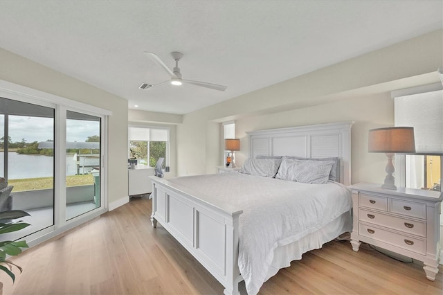 bedroom with ceiling fan, a water view, access to outside, and light hardwood / wood-style flooring