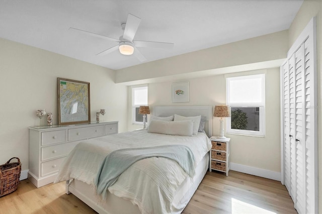 bedroom with ceiling fan, a closet, and light hardwood / wood-style floors