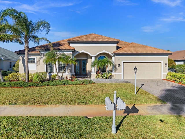 mediterranean / spanish house featuring a front lawn and a garage