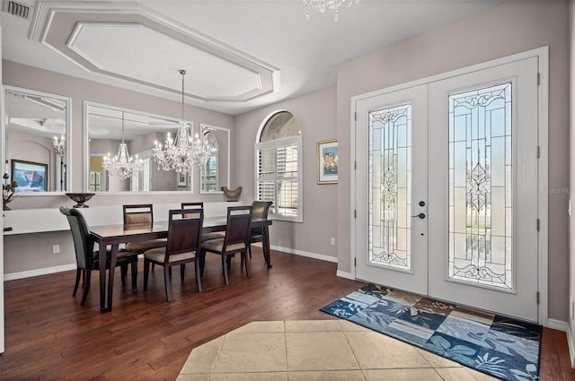 foyer entrance featuring a chandelier, french doors, dark wood-type flooring, and a textured ceiling