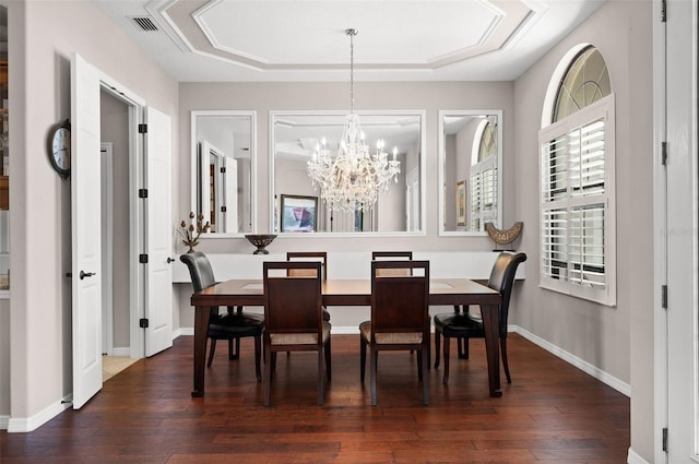 dining space with dark hardwood / wood-style flooring and a chandelier