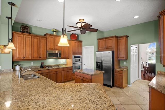 kitchen with stainless steel appliances, ceiling fan, sink, hanging light fixtures, and light tile patterned flooring