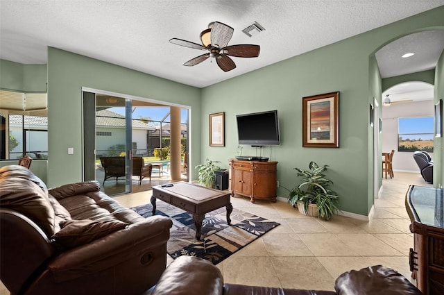 tiled living room featuring a textured ceiling and ceiling fan