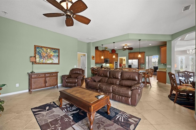 tiled living room featuring french doors and ceiling fan